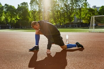 Man stretches his legs and stands on one knee