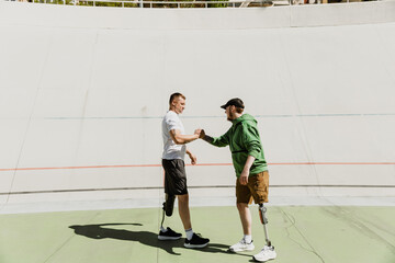 Two men standing and shaking hands while smiling