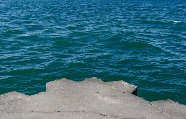 The concrete and stone pier at the Sodus Point Lighthouse on Lake Ontario New York looking out over the lake on a beautiful afternoon