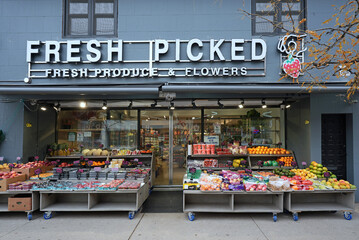 Fototapeta premium Independent grocery store with outdoor display of fruits and vegetables