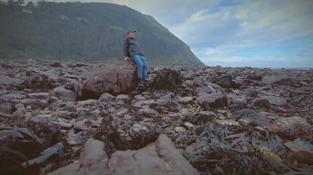 A hiker rambler tourist enjoys the delights of the North Coast of Devon in England via the South West Coastal Path.