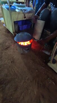 Cinematic vertical footage of a vendor grilling kerak telor at night. Videography of street food being prepared by the vendor in 4K resolution footage.