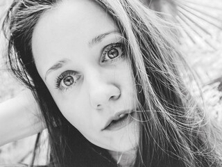 Close-up black-and-white portrait of a young woman with expressive eyes and natural beauty. Soft light, candid emotion, artistic mood create a modern aesthetic perfect for contemporary visual projects
