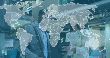 Woman tapping tablet, showing world map overlay, man leaning and checking business data in lobby - Powered by Adobe