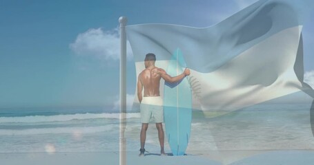 Man standing on shore holding blue surfboard while breeze rippling flag overlaying him surfing prep - Powered by Adobe
