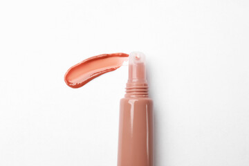 Beautiful nude lip gloss on white background, top view