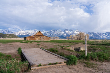 Storm clouds gather above the Teton Range, framing the rustic charm of the Moulton Barn.