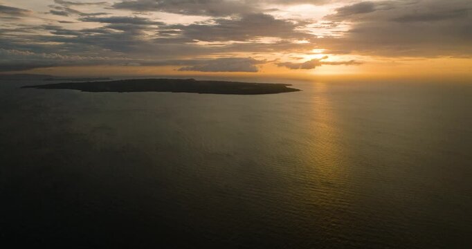 Beautiful sunset behind the clouds over Carabao Island. Romblon, Philippines.