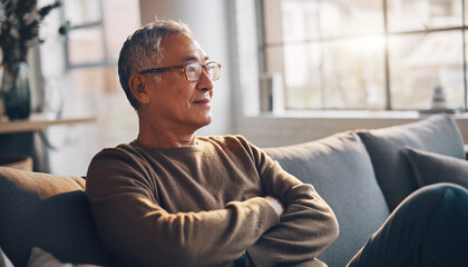 Contemplative Senior Man Relaxing on Sofa at Home, Thoughtful and Content
