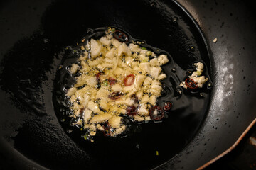 ニンニクと唐辛子をオリーブオイルで炒める様子