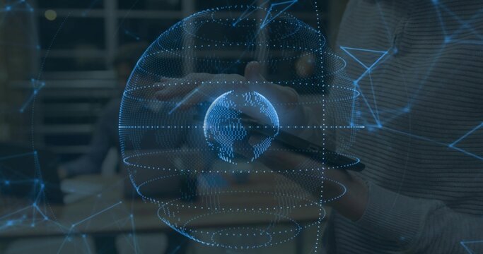 Projecting holographic globe aligning with hands and tablet in office, with staff in ribbed sweater