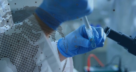 Using pipette, researcher in PPE transferring into vial at bench, microscope arm and map overlay