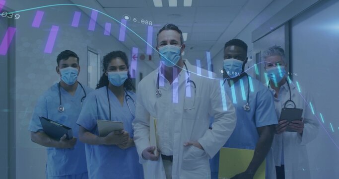 Standing male doctor in white coat holding file in hospital corridor, masked team and data overlay - Powered by Adobe