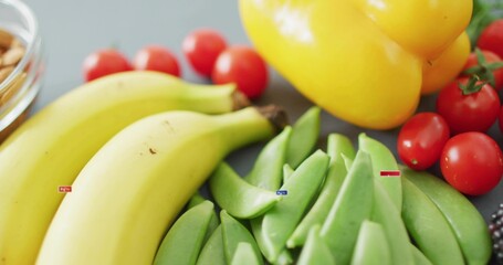 Displaying ripe bananas and green snap peas on gray counter, with tomatoes bell pepper nuts labels