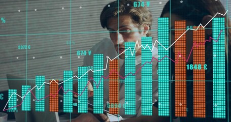 Reviewing two professionals in shirts leaning over laptop in office, finance charts and coffee