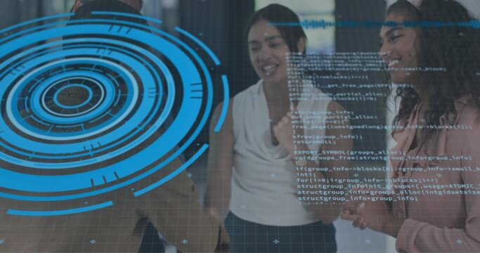 Collaborating team in business casual viewing glass panel in office, showing blue HUD and code