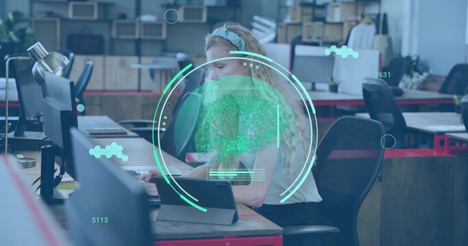 Working woman in blouse, dark pants using monitors and tablet at open office with teal overlay - Powered by Adobe