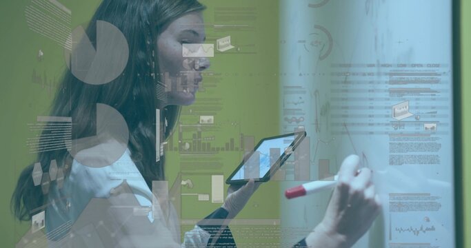 Writing woman in blouse and jacket marking board in office holding tablet, red marker with charts