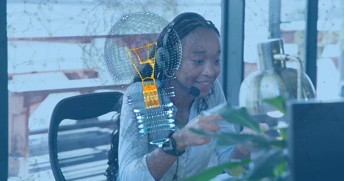 Pointing woman wearing headset and blouse leaning toward computer at office with holo lightbulb - Powered by Adobe