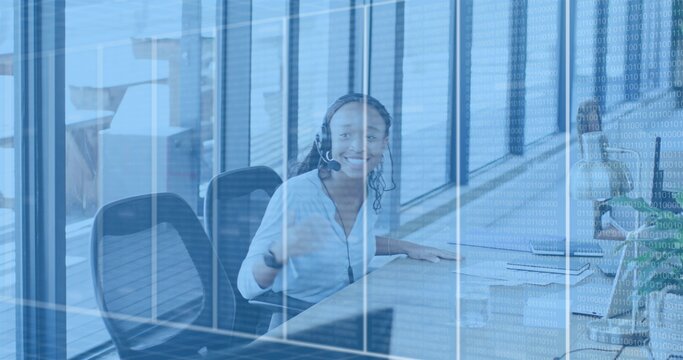 Smiling woman in blouse wearing headset answering calls at office desk, glass binary overlay - Powered by Adobe