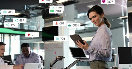 Leading woman in top with tablet guiding meeting at office with laptop floating badges, copy space