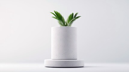 A single green palm frond emerges from a speckled concrete planter, which sits on a matching concrete pedestal against a plain, light gray studio background. Th