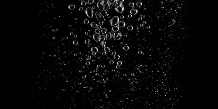 Clear water bubbles rising in dark background, abstract underwater texture ideal for design, science, and creative projects. Perfect for backgrounds, overlay, or refreshing clean concept visuals.