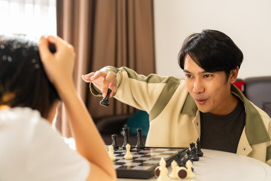 Man lifestyle playing chess strategy game with opponent indoors focused and engaged