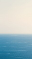 Obraz premium A tranquil, ultra-minimalist horizon where a calm, clear blue ocean meets a soft, pale sky, suggesting vast open space and profound serenity ,potential ,background ,pure
