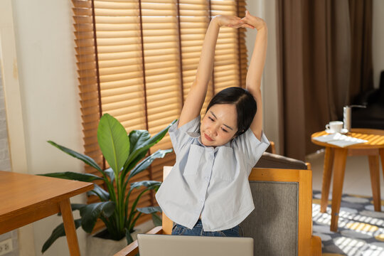 Young woman stretching arms sitting chair