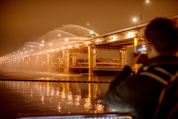 Banpodaegyo Bridge. A person captures the stunning water show under a bridge in Seoul, surrounded...