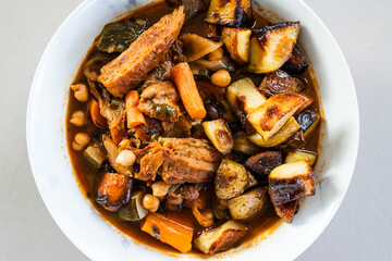 veggie stew bowl with roasted potatoes carrots zucchini and plant based chicken strips