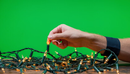 Hand Adjusting Christmas Lights on Green Screen
