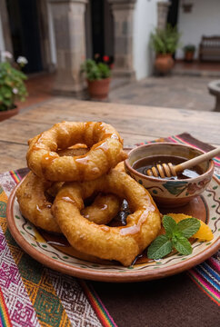 Picarones, a traditional Peruvian dessert made from pumpkin and sweet potato with chancaca honey, delicious food, Peru