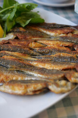 Freshly cooked fish served with herbs and lemon on a platter