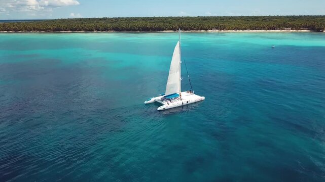 4k 24fps drone shoot of the catamaran in the saona island in the caribbean sea with blue water in a sunny day 4
