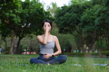 Woman practicing calm pranayama breathing exercise at park