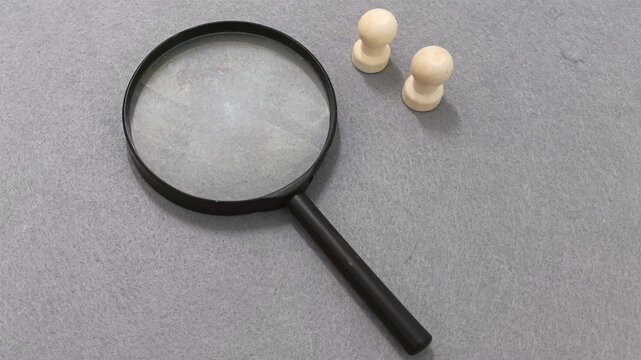 Magnifying glass and pawns symbolizing strategy, examination, and the pursuit of knowledge