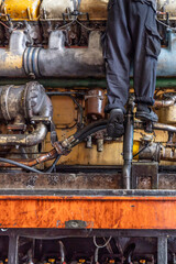 A train engineer technician is working on the maintenance of an old train.