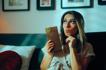 Woman In Doubt About Eating a Large Chocolate Bar with Pistachios. Person trying to lose weight...
