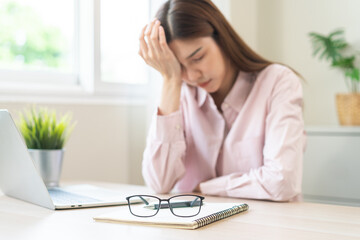 Stressed, exhausted asian young woman having migraine symptoms headache, bored sitting work long...