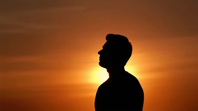 Silhouette of a Man Watching the Golden Sunset.