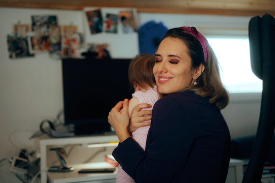 Mom Working Remotely Hugging her Baby While in a Quick Break. Freelance mom makes her scheduled balanced to include family time