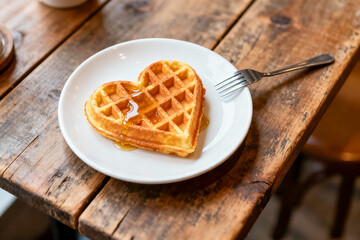 Fresh homemade heart shape waffles on white plate