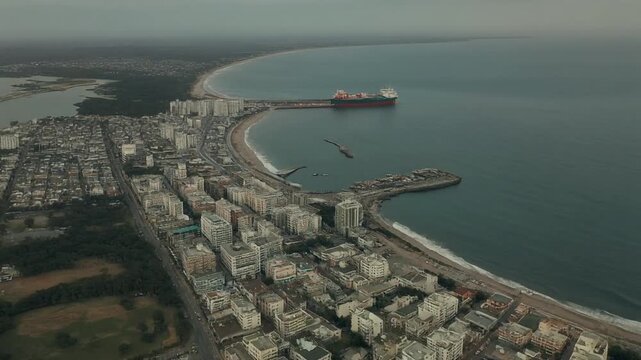 Aerial View of a Coastal City with a Large Ship in the Harbor.