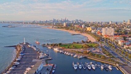 Panoramic Aerial View of Melbourne's St Kilda Coastline, Featuring a Bustling Marina, Lighthouse, Sandy Beach, and City Skyline