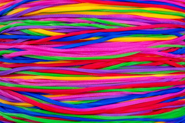 a dense, chaotic tangle of colorful intertwined elastic rubber bands in vibrant shades