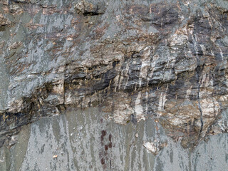 Rugged Rock Face With Multicolored Slopes and Coarse Texture in Natural Cliff Scene