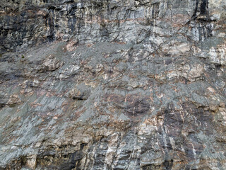 Rugged Rock Face With Multicolored Slopes and Coarse Texture in Natural Cliff Scene
