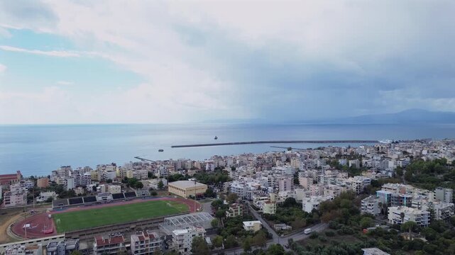 Aerial wide panoramic view of Messinian gulf, taken from Kalamata city on a cloudy autumn day 4K push out, drop down drone movement
